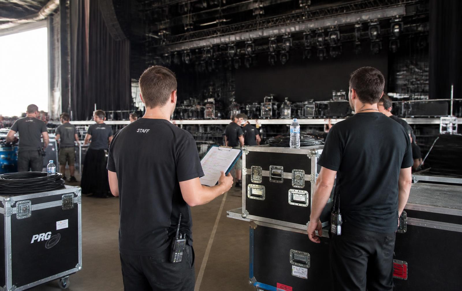 Equipe de produção em backstage durante a montagem